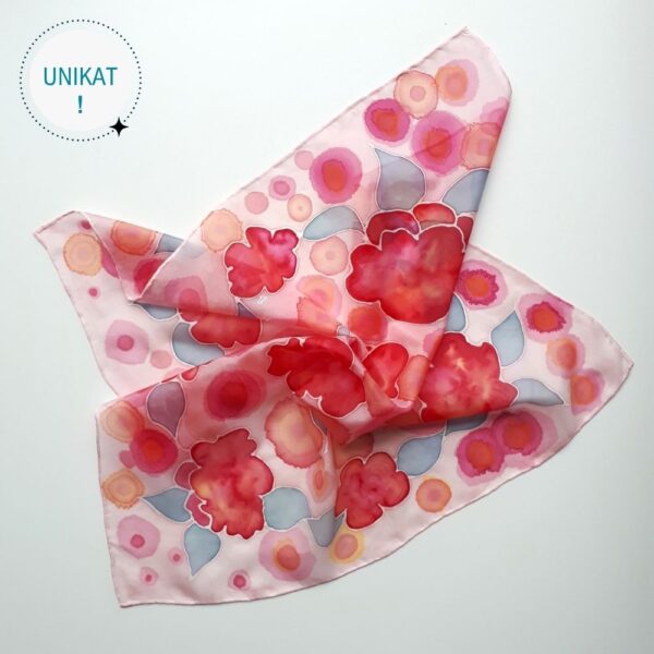 Ręcznie malowana apaszka jedwabna z motywami abstrakcyjnych kwiatów w kolorach czerwieni na pudrowo różowym tle z elementami kolorów różu, moreli, błękitu listków.