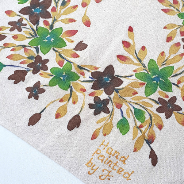 Torba bawełniana w kolorze naturalnym z ręcznie namalowanym motywem kwiatowego wianka - kwiaty w kolorze zieleni pistacji i czekoladowego brązu w otoczeniu gałązek w odcieniu podpalanej na czerwono ochry