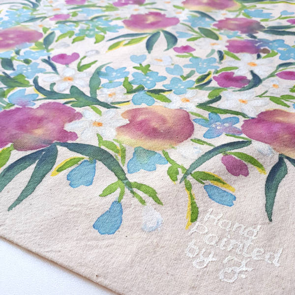 Ujęcie w powiększeniu z podpisem autorki - Torba bawełniana w kolorze naturalnym z ręcznie namalowanym motywem kwietnym - róże, margerytki i niezapominajki kaukaskie w otoczeniu zieleni gałązek